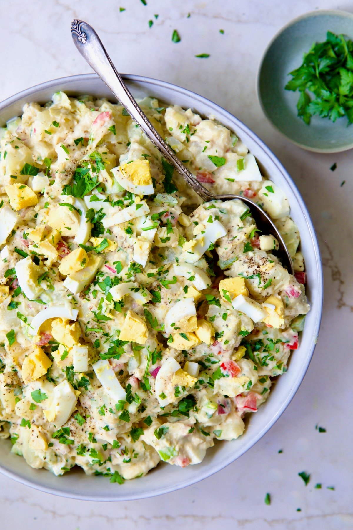 Potato Salad with Horseradish Dressing in light blue bowl with serving spoon.