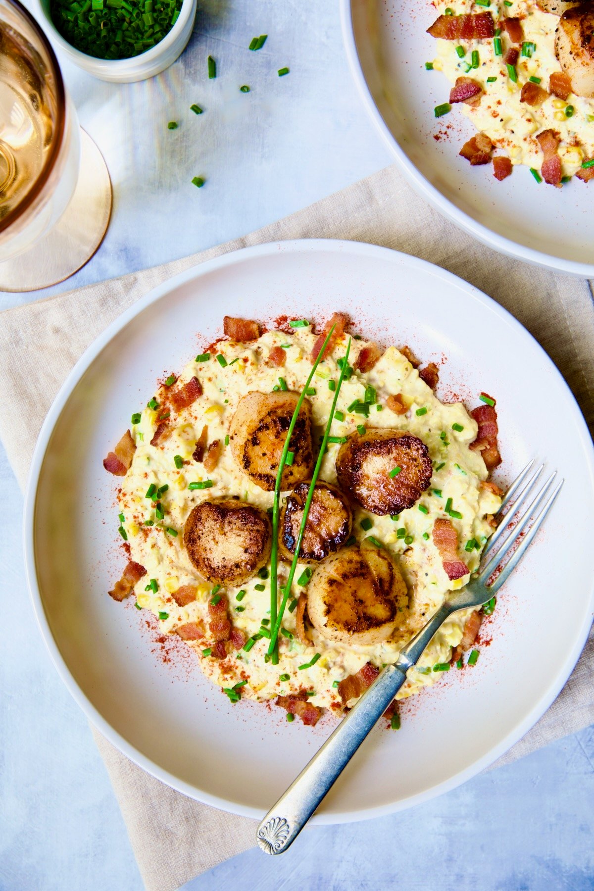 One serving of Seared Sea Scallops with Smoky Sweet Corn Puree on white plate.