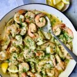 Shrimp Scampi with Artichokes in white enamel cast iron pan with serving spoon.