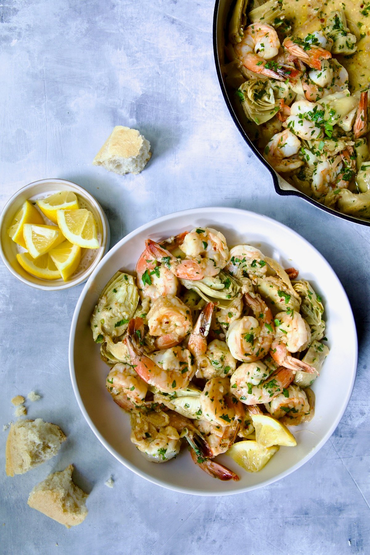 Shrimp Scampi with Artichokes in white bowl.