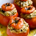 Four Cheesy Rice Stuffed Tomatoes in white baking dish.
