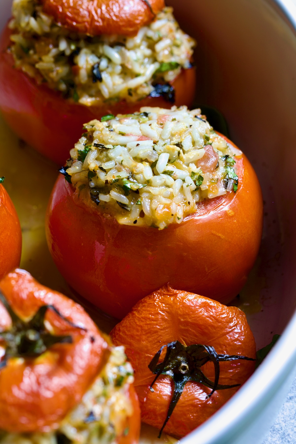 Close-up of one of the Cheesy Rice Stuffed Tomatoes with the top removed to expose the filling.