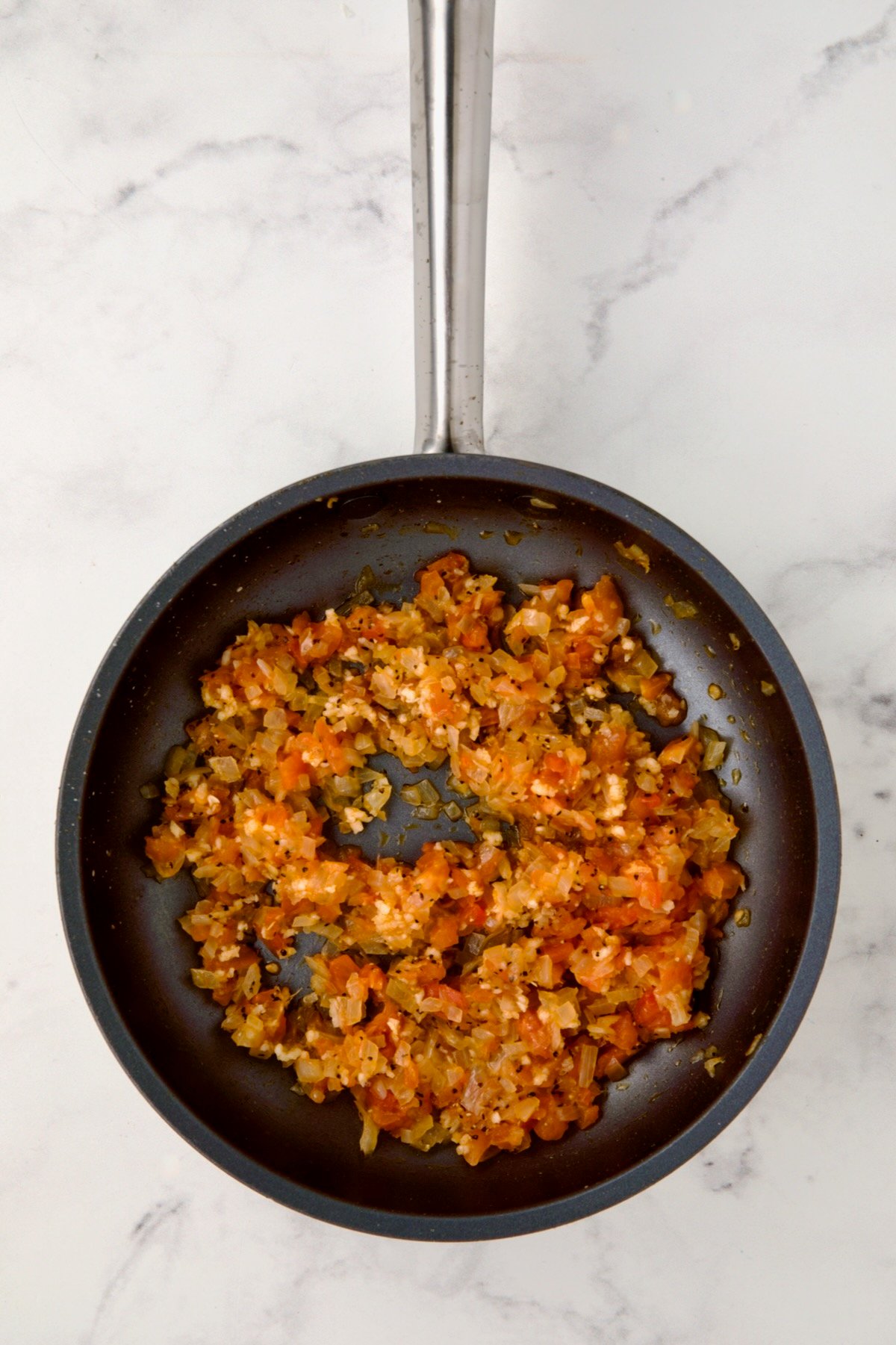 Cooked onions and tomato pulp in nonstick skillet.