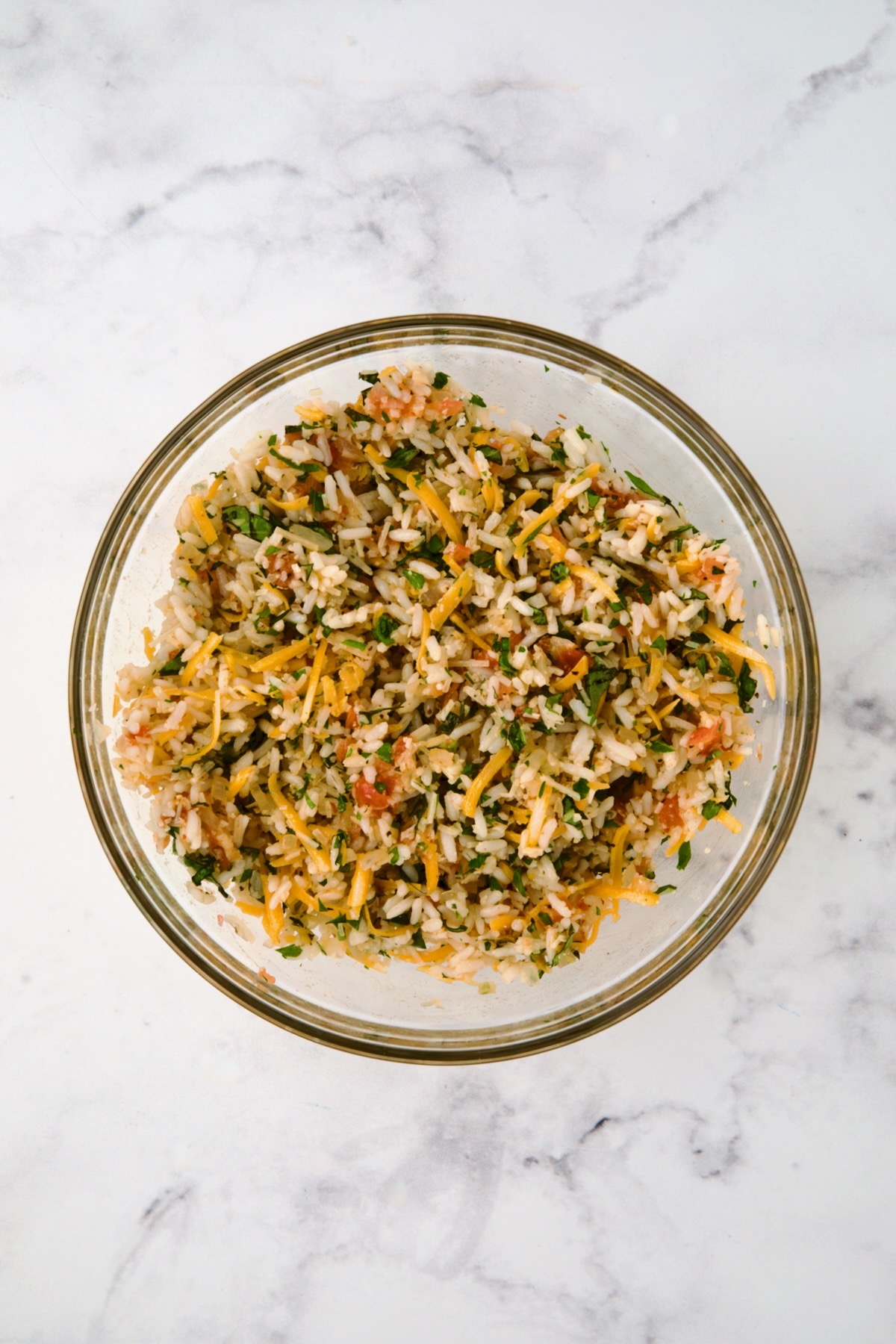 Filling for Cheesy Rice Stuffed Tomatoes in glass bowl after being mixed together.