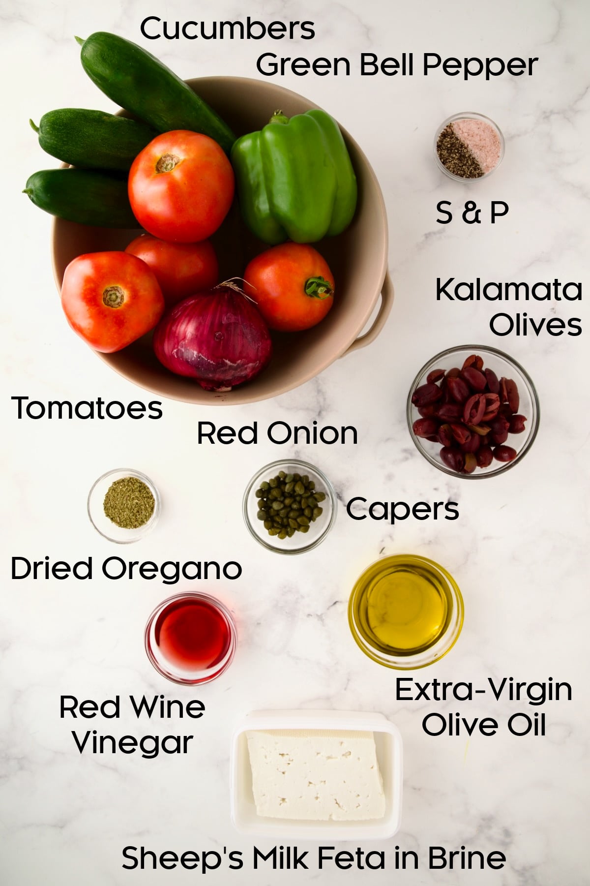 Ingredients for Classic Greek Salad with vegetables in a colander and the remaining ingredients in glass bowls.