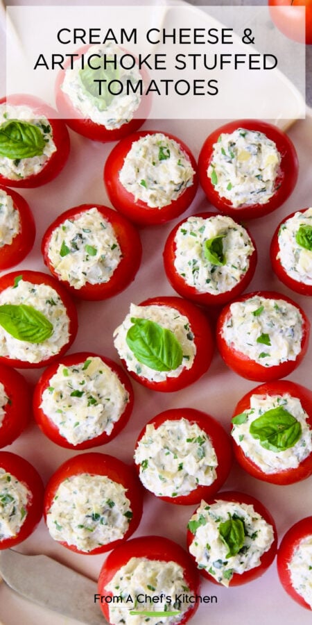 Pinterest graphic for Cream Cheese and Artichoke Stuffed Tomatoes on white platter garnished with small fresh basil leaves.