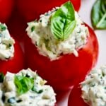 Cream Cheese and Artichoke Stuffed Tomatoes garnished with fresh basil leaves.
