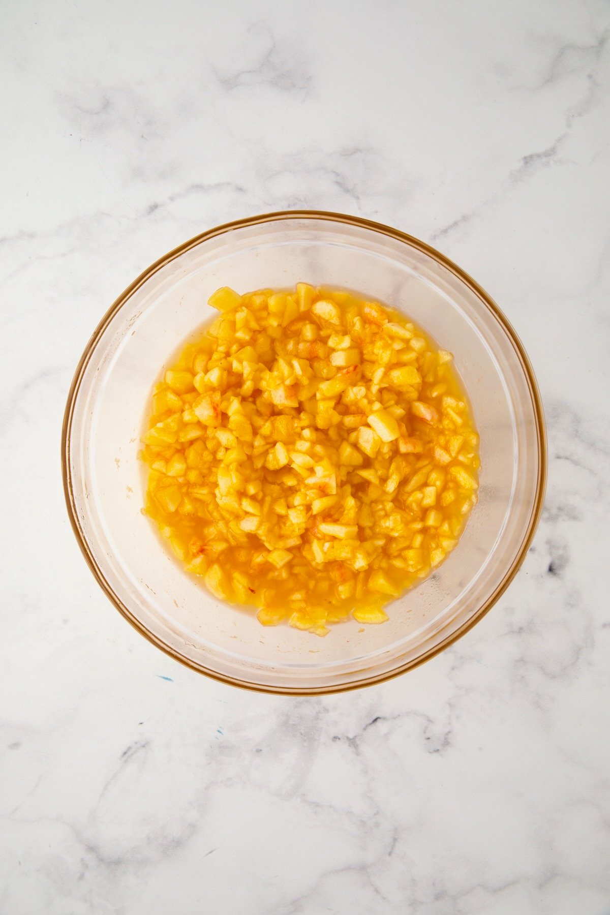 Chopped peach pieces in glass bowl.