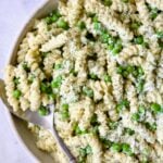 Creamy Cucumber Pasta Salad in white serving bowl with serving spoon.