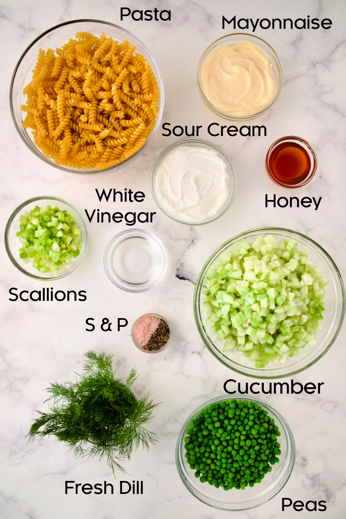 Ingredients for Creamy Cucumber Pasta Salad in glass bowls.