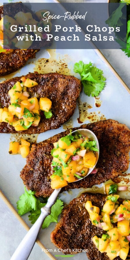 Pinterest graphic for Grilled Pork Chops with Peach Salsa showing them on a gray oval platter with spoon.