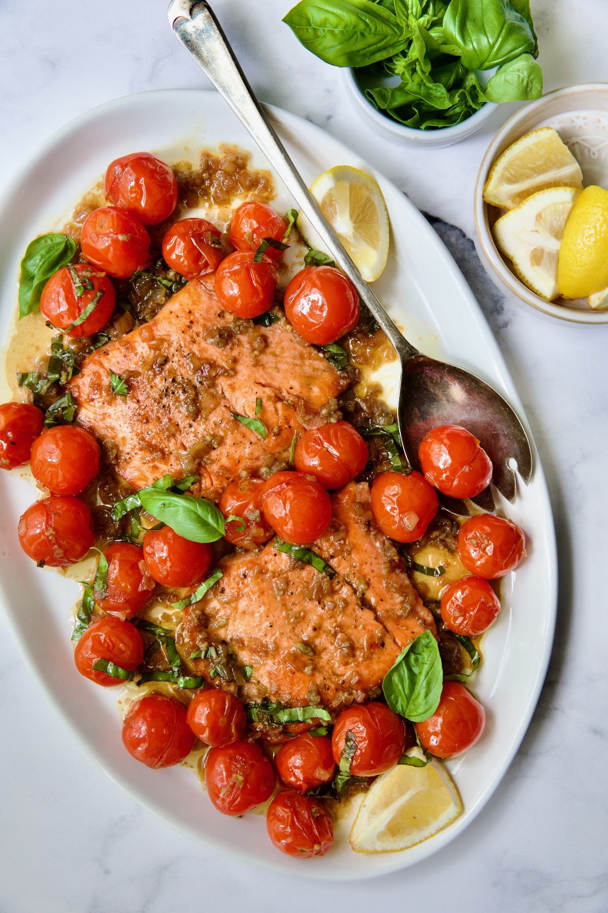Salmon with Balsamic Cherry Tomatoes on oval white platter with serving fork.