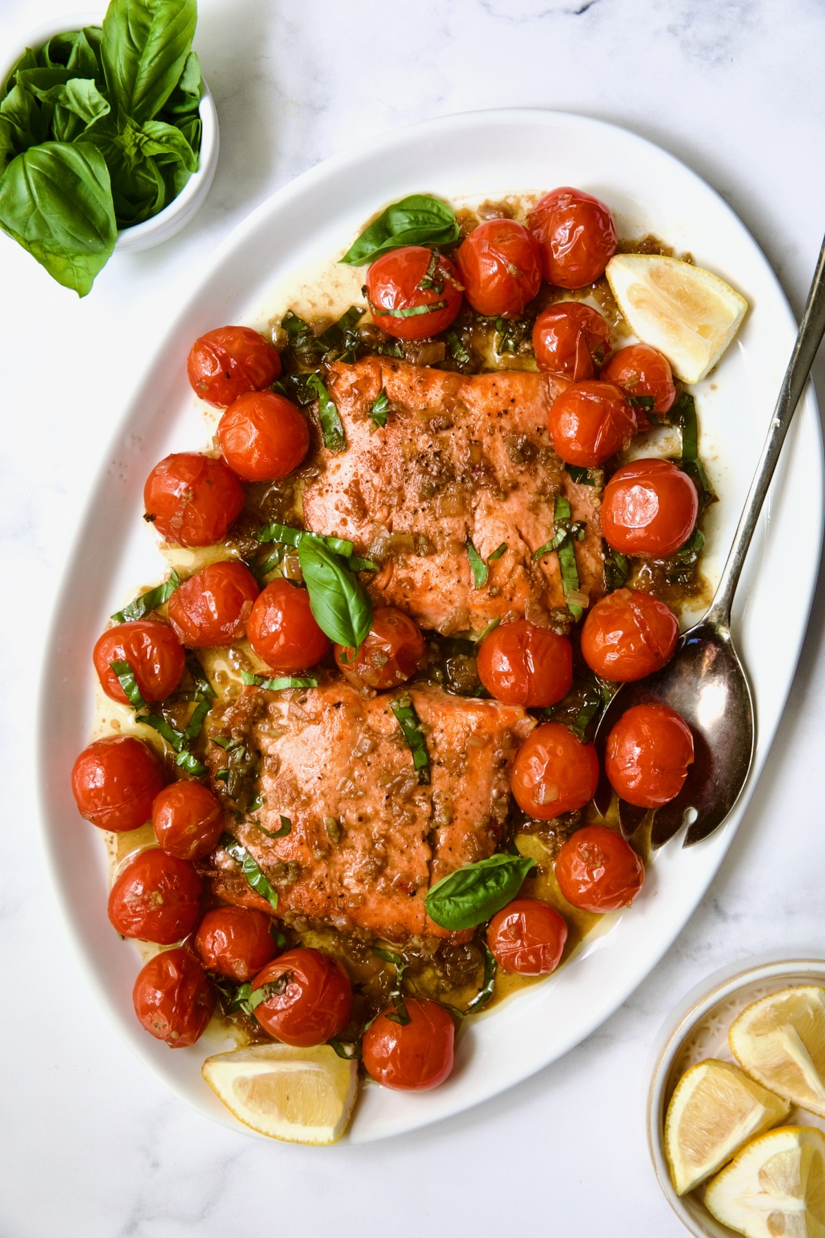 Salmon with Balsamic Cherry Tomatoes on oval white platter with serving fork.