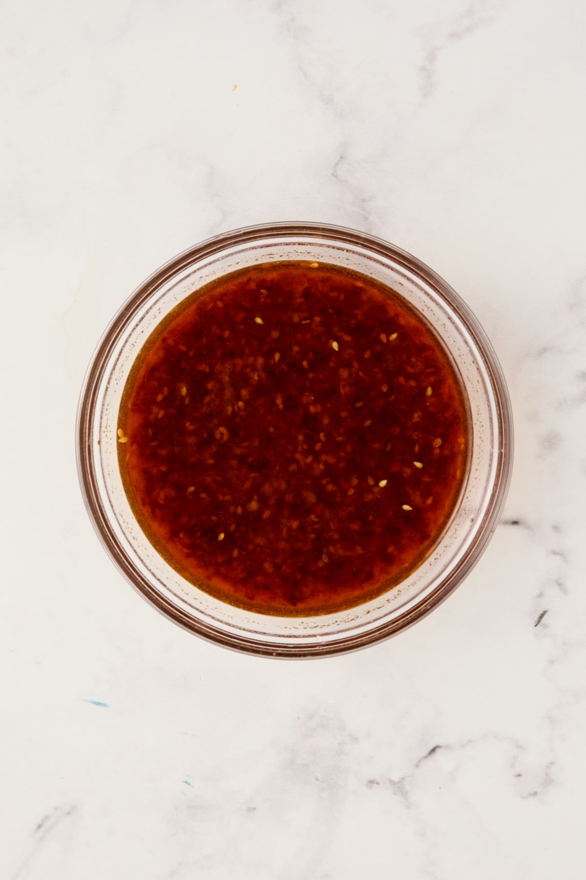 Dressing for cucumber salad in glass bowl.