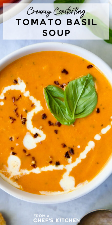 Pinterest graphic for Creamy Tomato and Basil Soup showing it in a white soup mug garnished with fresh basil, cream and red pepper flakes.