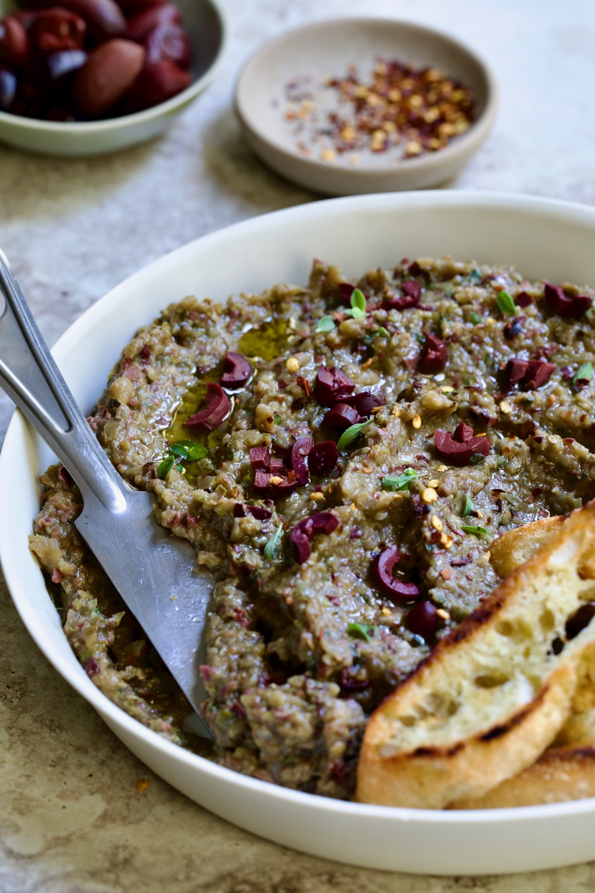 Eggplant Caviar (Caviar d'Aubergine) in white bowl with knife.