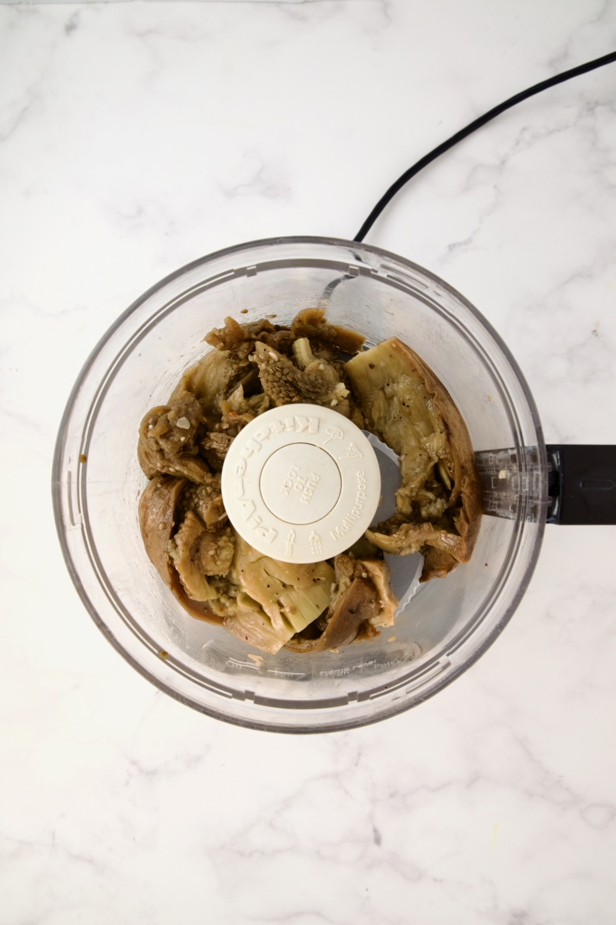 Cooked eggplant in food processor before other ingredients are added.