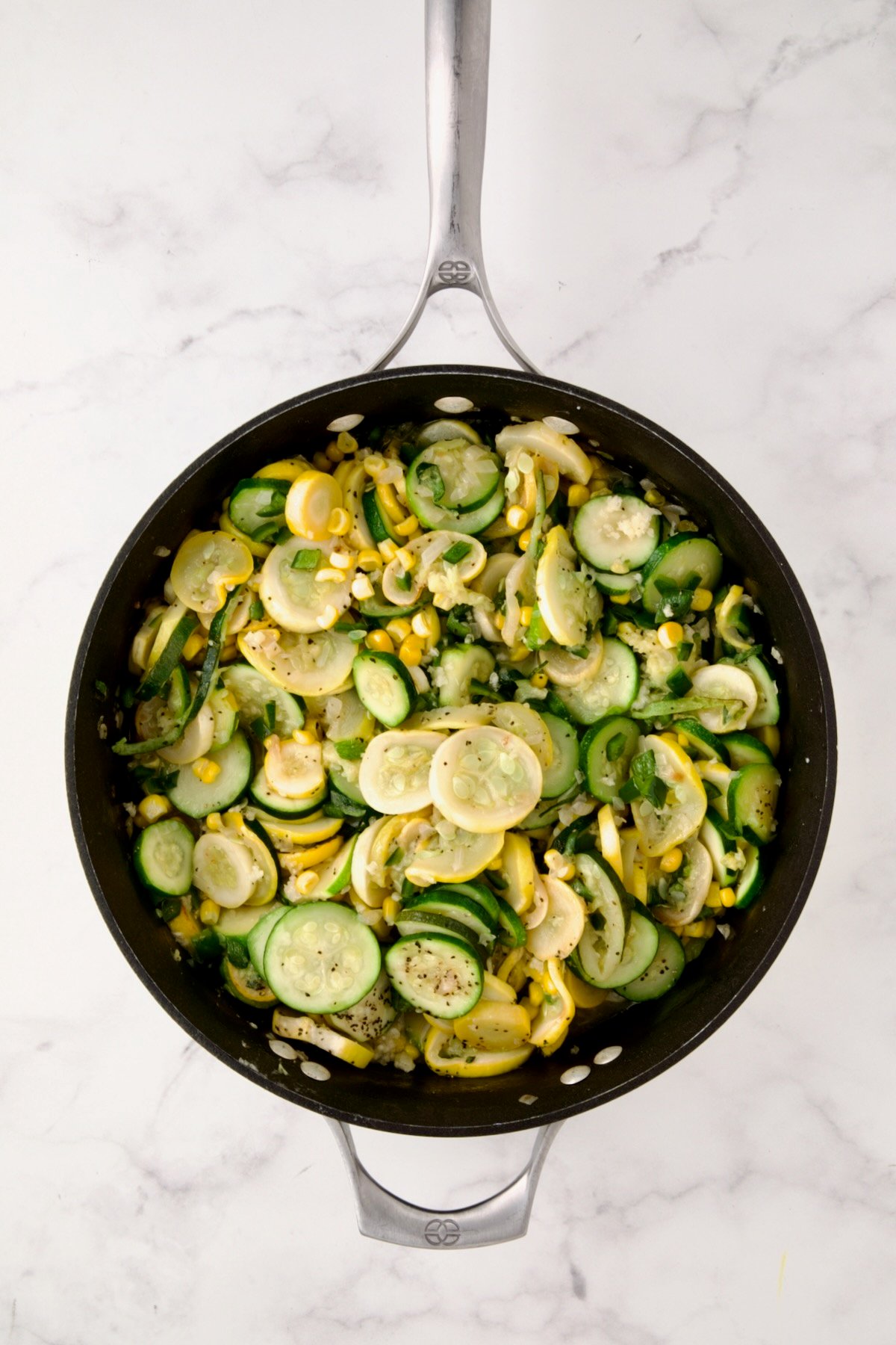 Cooked zucchini, yellow squash and poblano in nonstick skillet with corn added.