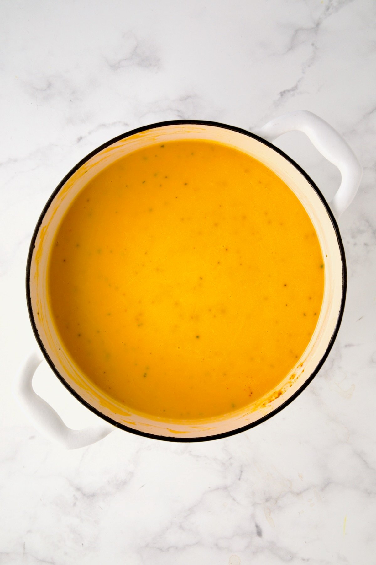 Finished Butternut Squash Brie Soup in white enamel Dutch oven.