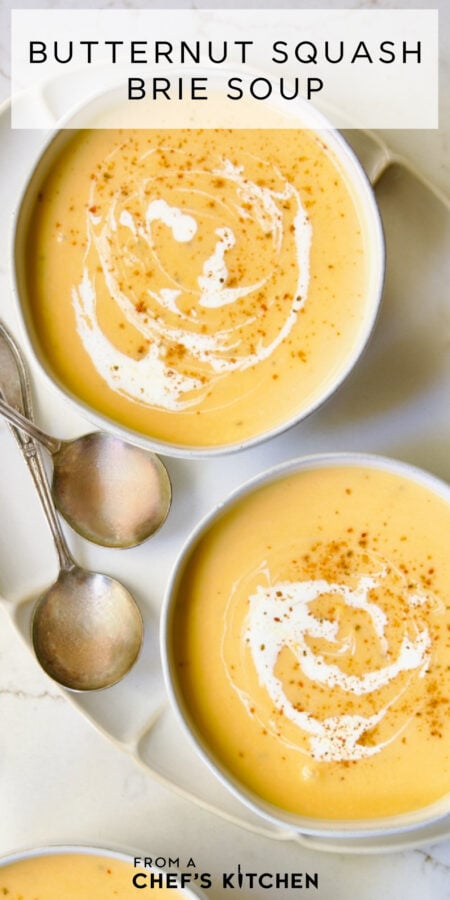Pinterest graphic for Butternut Squash Brie Soup showing two bowls on an oval white platter.