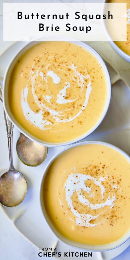 Pinterest graphic for Butternut Squash Brie Soup showing two bowls on an oval white platter.