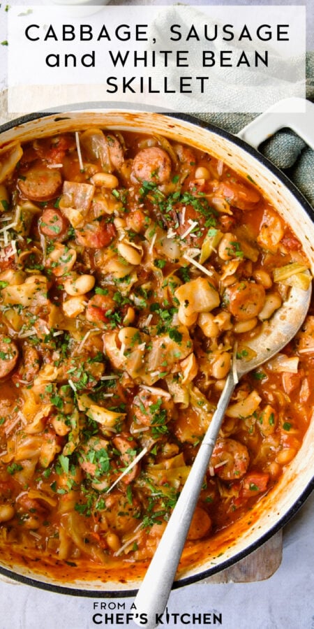 Pinterest graphic for Cabbage, Sausage and White Bean Skillet showing it in a white enamel cast iron skillet with serving spoon.