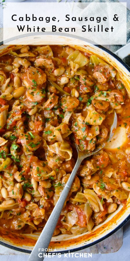 Pinterest graphic for Cabbage, Sausage and White Bean Skillet showing it in a white enamel cast iron skillet with serving spoon.