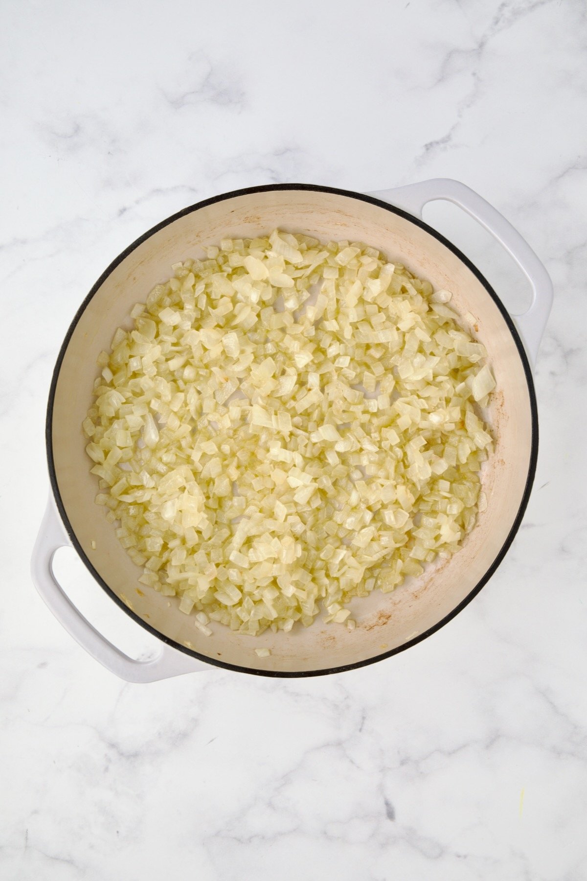Cooked onions in white enamel cast iron.