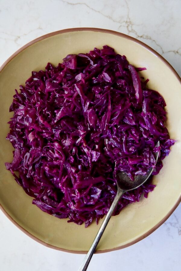Sweet and Sour Red Cabbage in earthenware bowl with serving spoon.