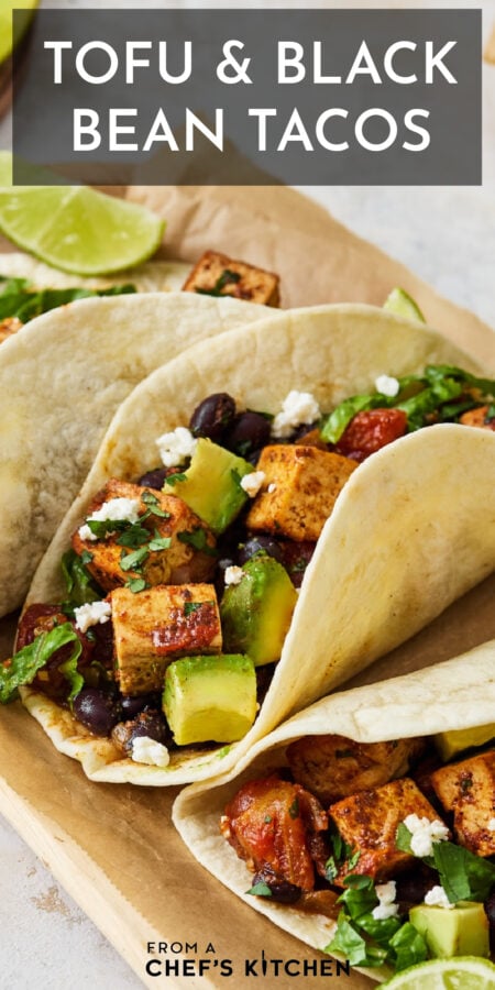 Pinterest graphic for Tofu and Black Bean Tacos showing one on a parchment paper-lined wooden tray.