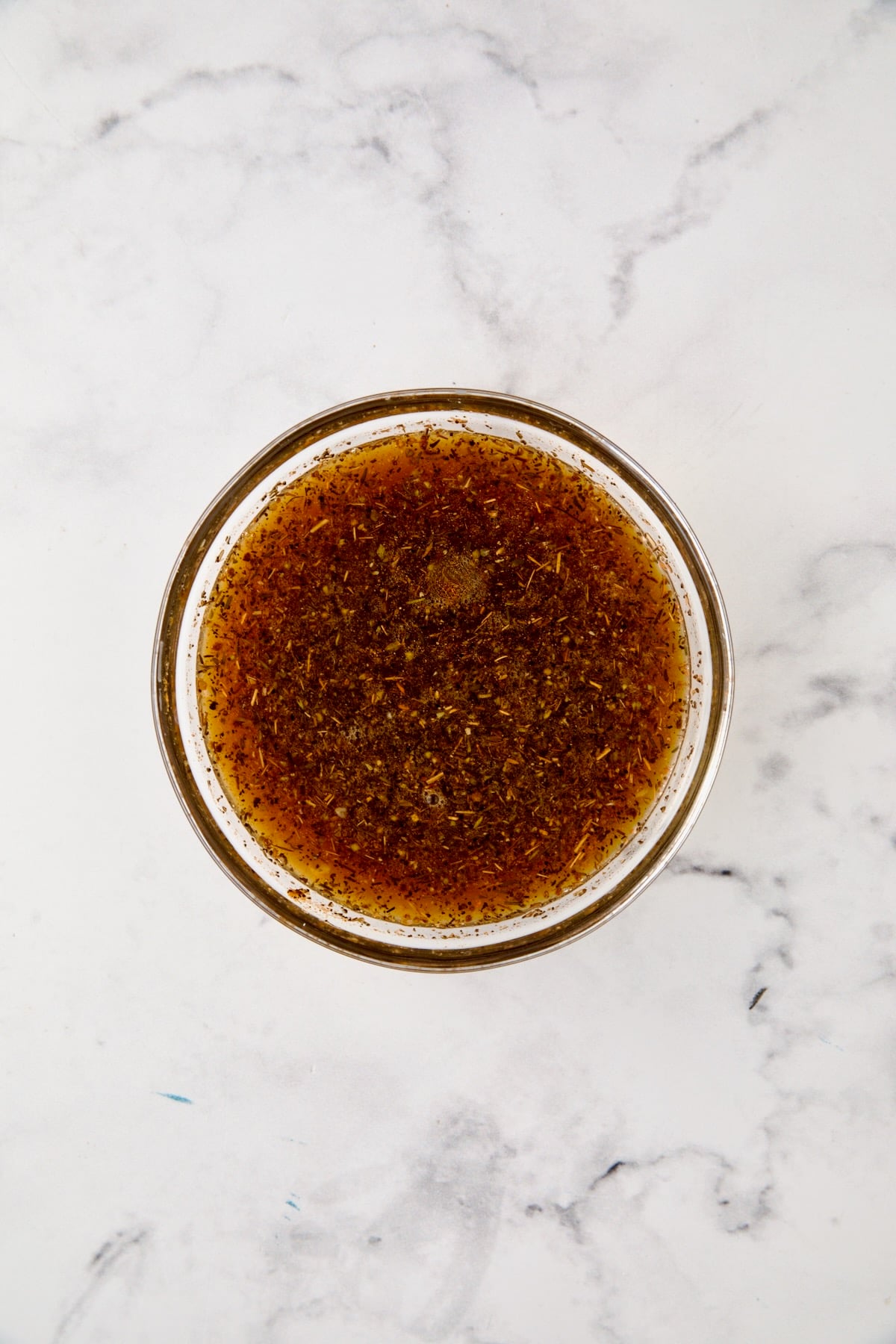 Herb and broth blend in glass bowl.