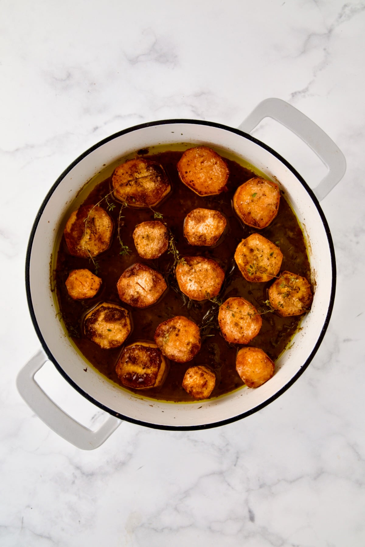 Finished Fondant Sweet Potatoes in round enamel cast iron skillet.
