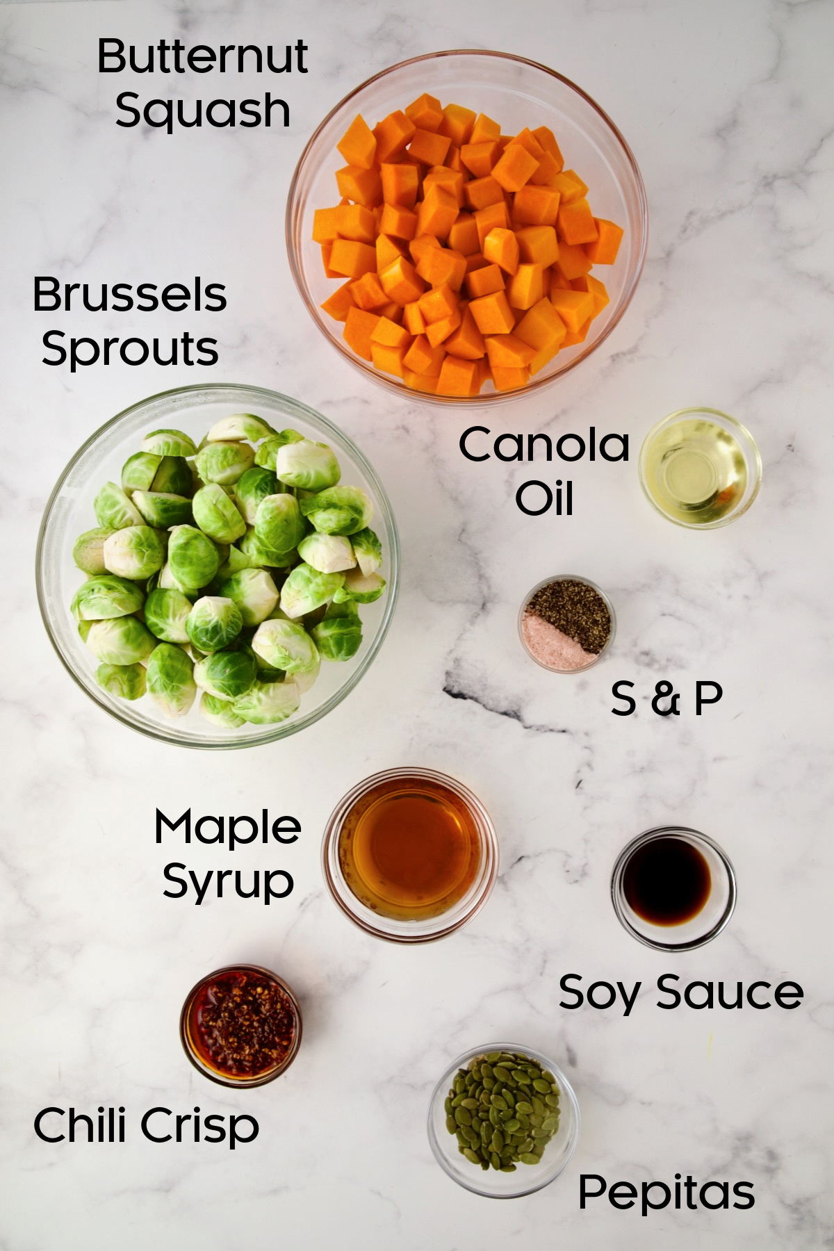 Ingredients for Maple Chili Crisp Brussels Sprouts and Butternut Squash in glass bowls.