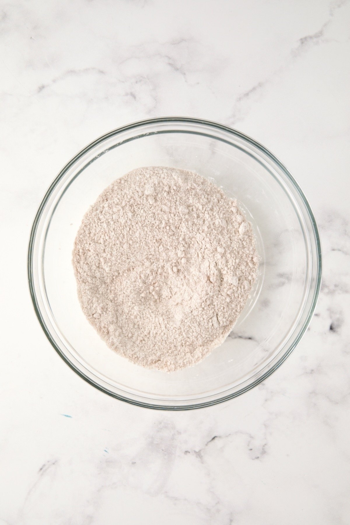 Dry ingredients for muffins in glass bowl.
