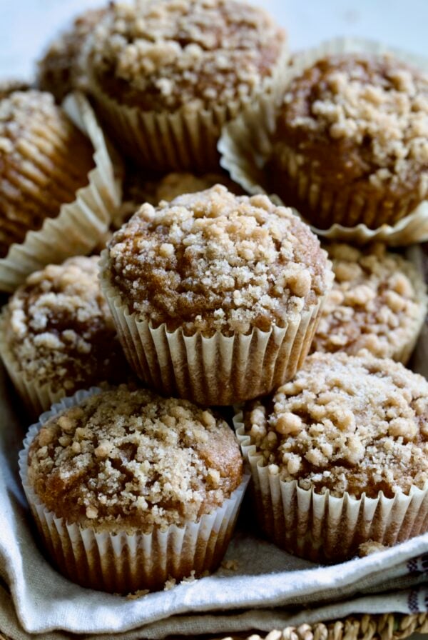 Stack of Pumpkin Streusel Muffins on napkin-lined basket.