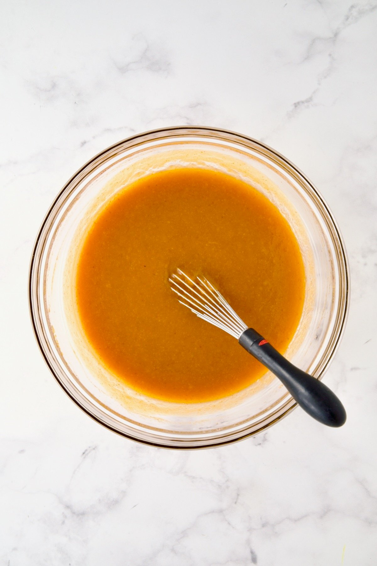 Wet ingredients for muffins in glass bowl.