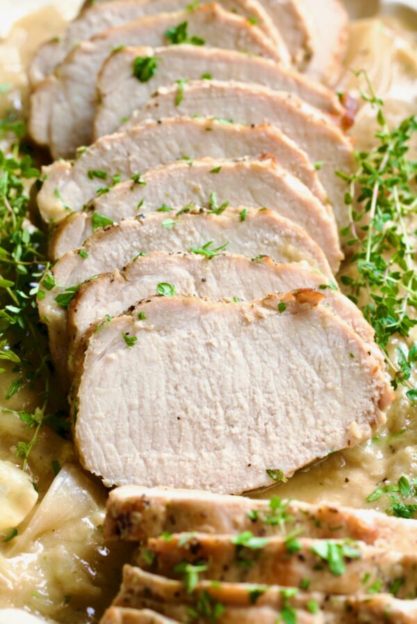 Braised Pork Loin in Dijon Mustard Sauce garnished with thyme sprigs.