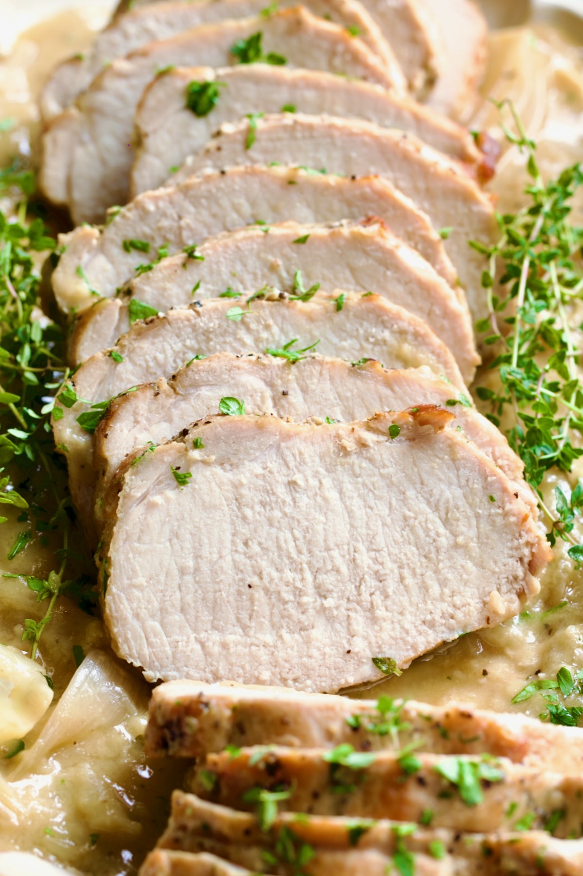 Braised Pork Loin in Dijon Mustard Sauce garnished with thyme sprigs.