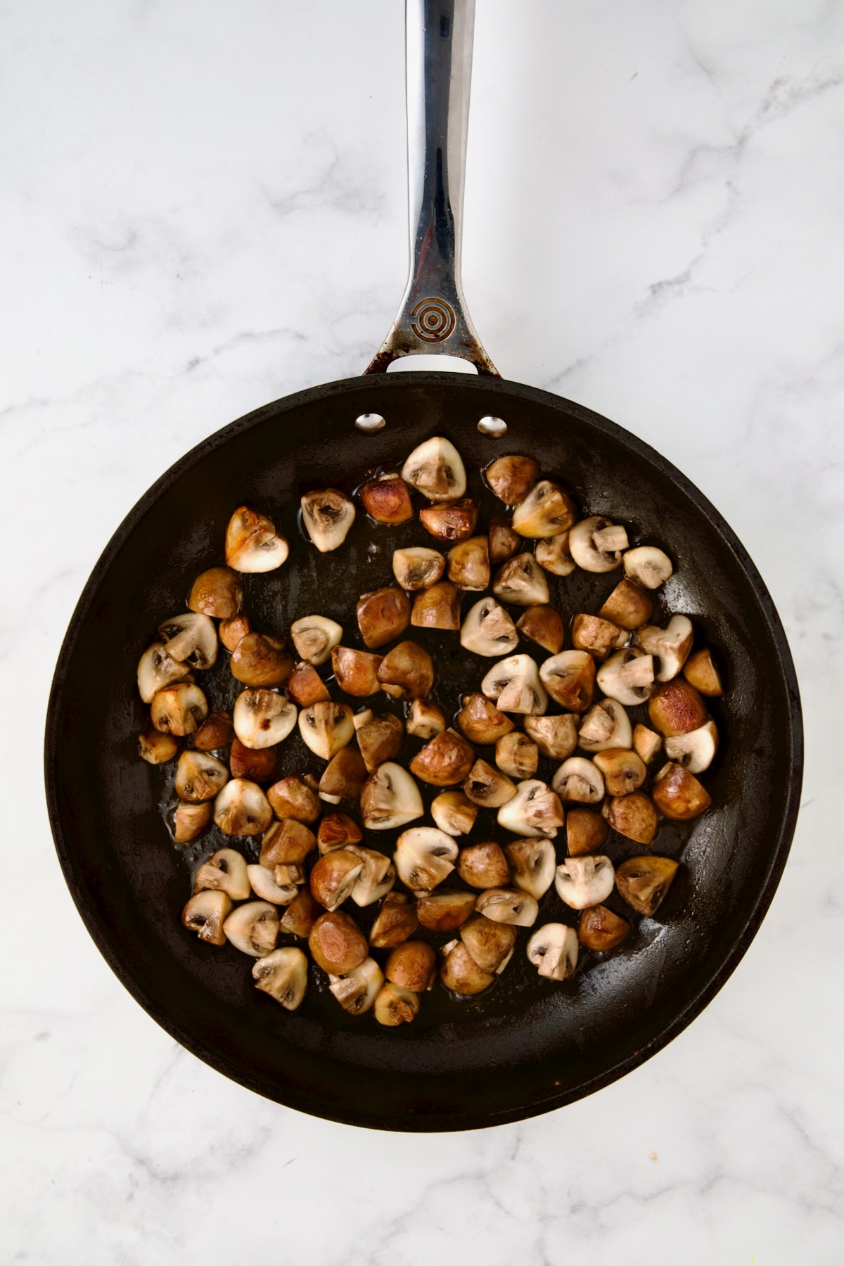 Browned cremini mushrooms in nonstick skillet.