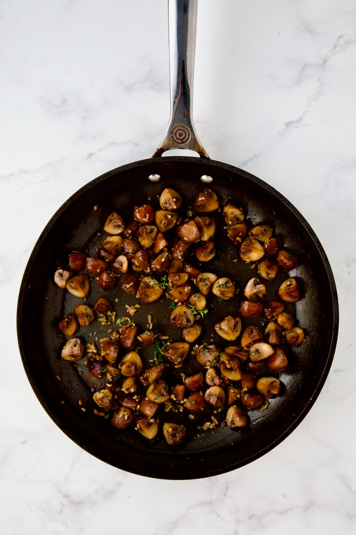 Browned cremini mushrooms in nonstick skillet with garlic cooked, and sherry and fresh thyme added.