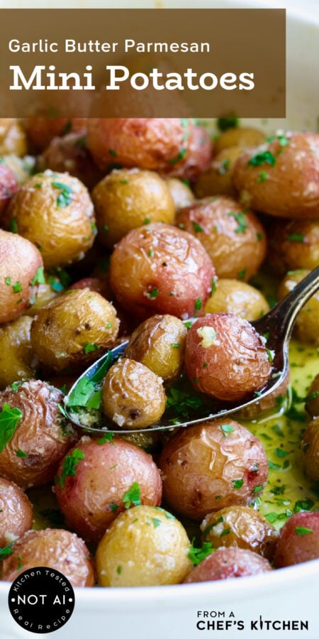 Pinterest graphic for Garlic Butter Parmesan Mini Potatoes showing them in a white baking dish with three being lifted out with a serving spoon.