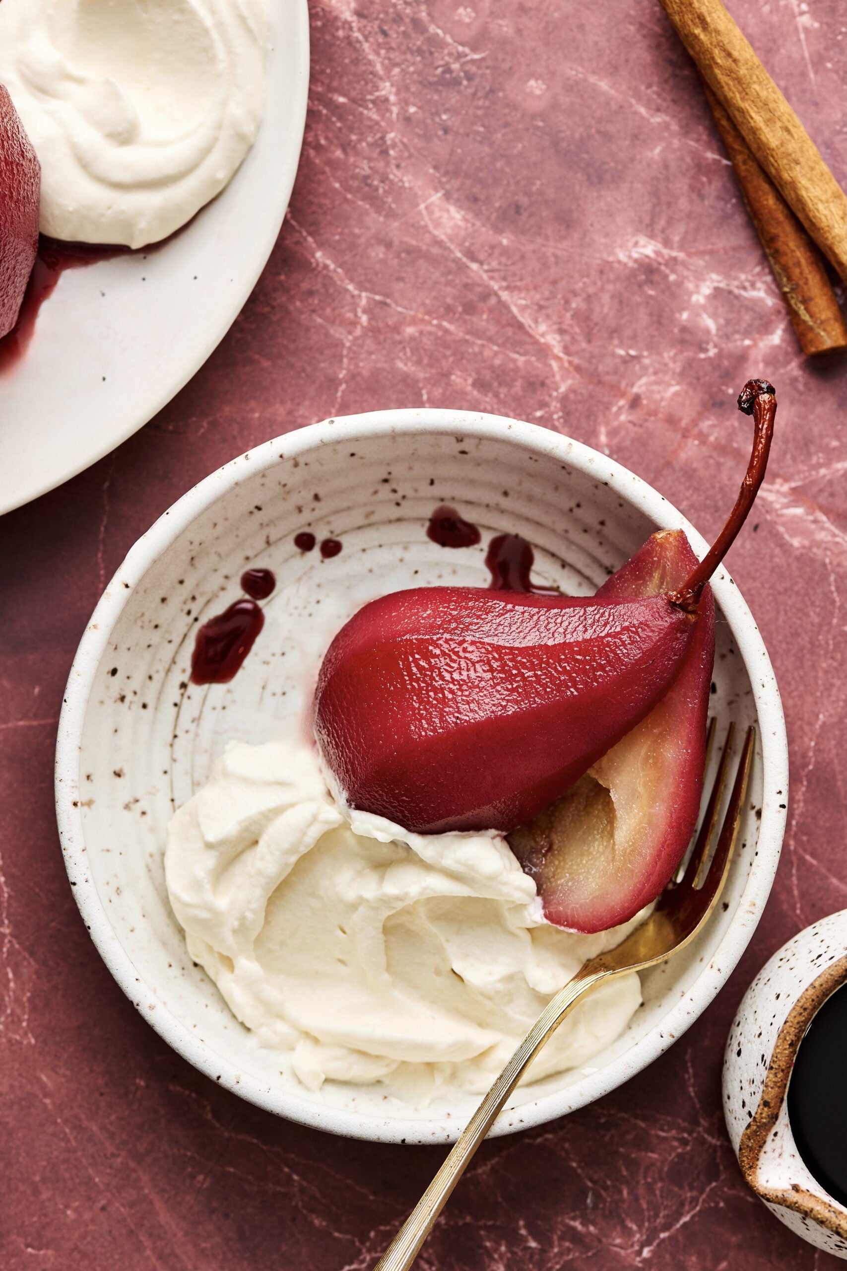 One serving of Red Wine Poached Pears in serving bowl with fork.