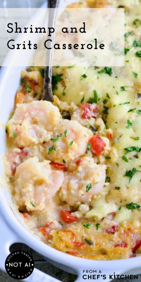 Pinterest graphic for Shrimp and Grits Casserole showing it in an oval white baking dish with serving spoon scooping up some shrimp.