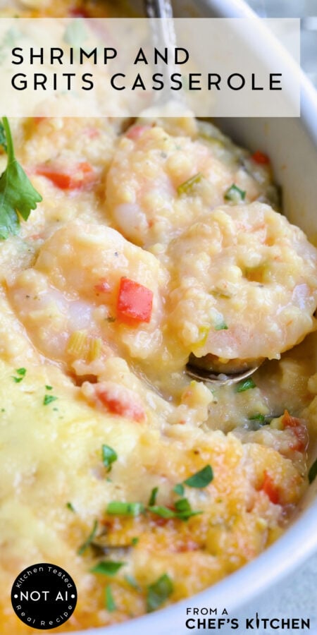 Pinterest graphic for Shrimp and Grits Casserole showing it in an oval white baking dish with serving spoon scooping up some shrimp.