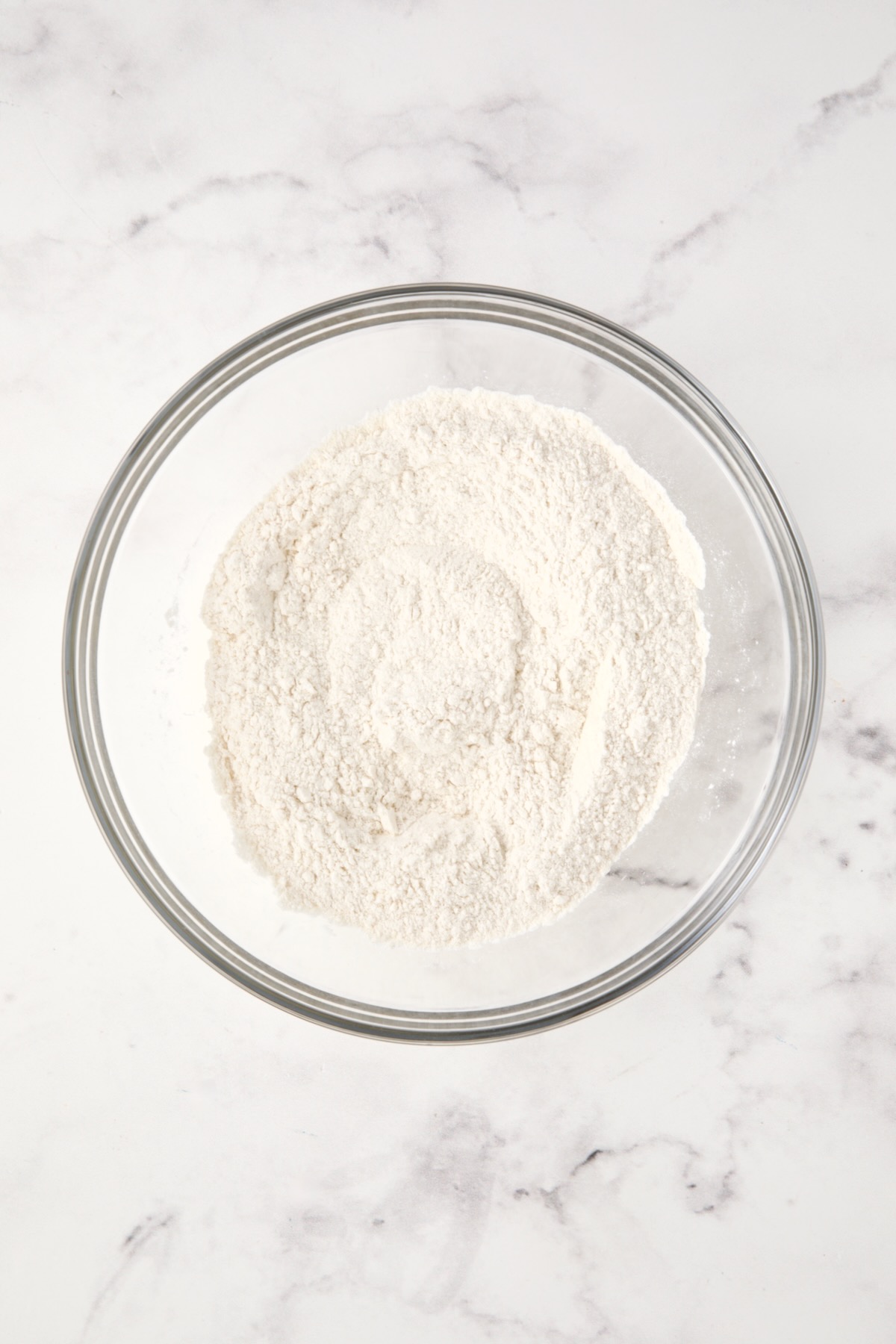 Dry ingredients for biscuits in glass bowl.