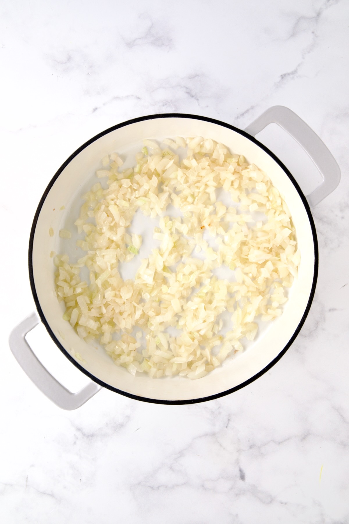 Cooked onions in white enamel cast iron skillet.