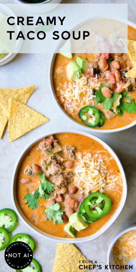Pinterest graphic for Creamy Taco Soup showing two servings in a white bowl garnished with tortilla chips, avocado, jalapeno and cilantro.