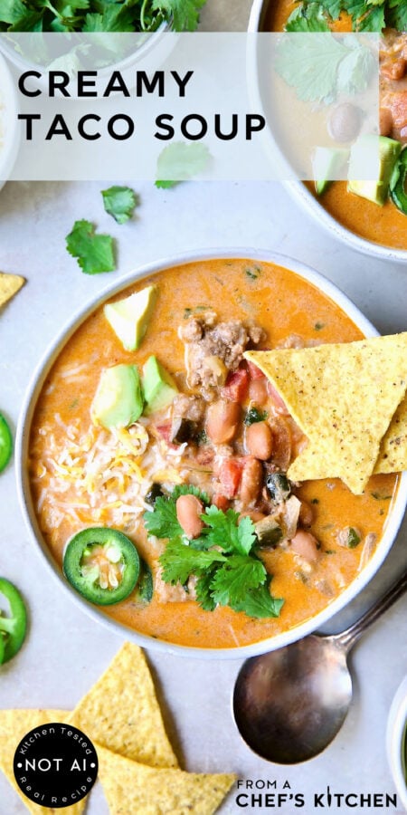 Pinterest graphic for Creamy Taco Soup showing one serving in a white bowl garnished with tortilla chips, avocado, jalapeno and cilantro.