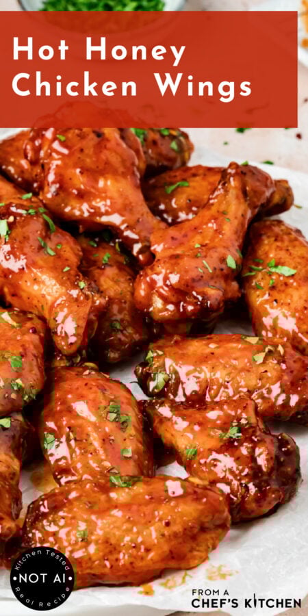 Pinterest graphic for Hot Honey Chicken Wings showing them glazed on a parchment paper lined platter.