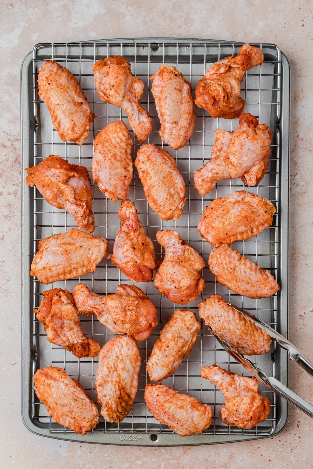 Wings on rack-lined rimmed baking sheet before being baked.